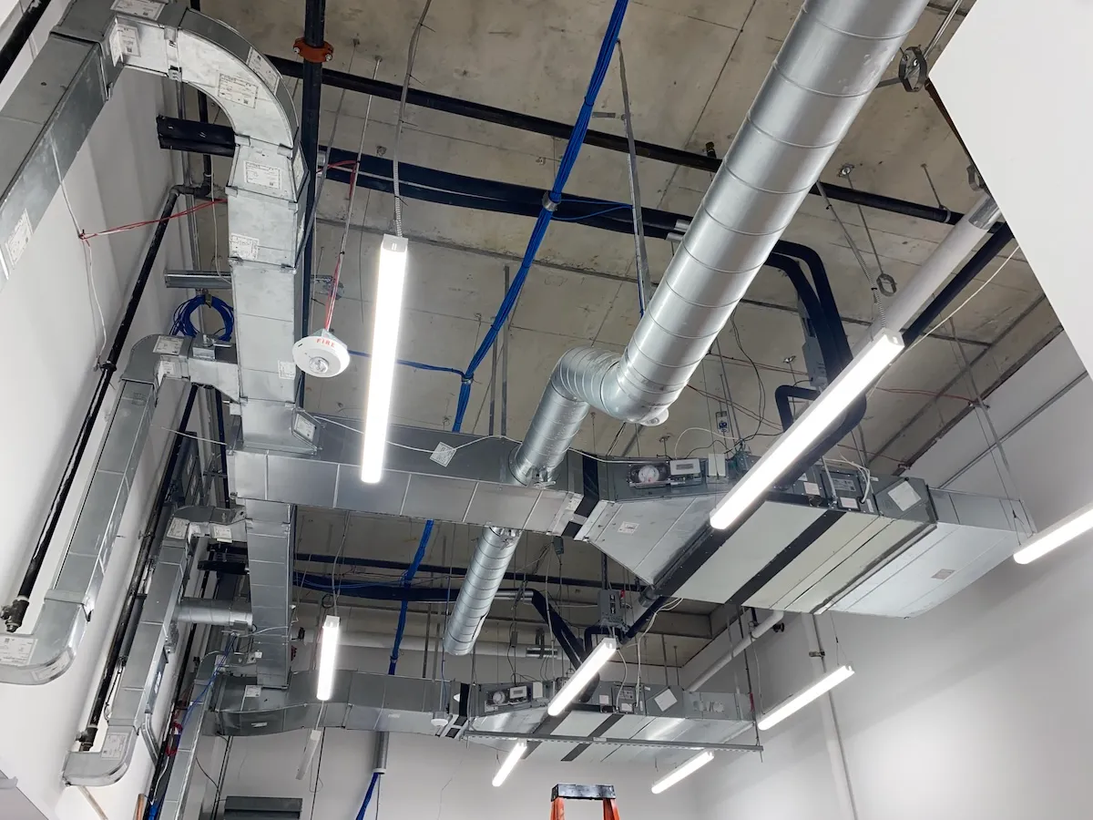 Dense network of rectangular and spiral ductwork during a commercial ceiling rough-in