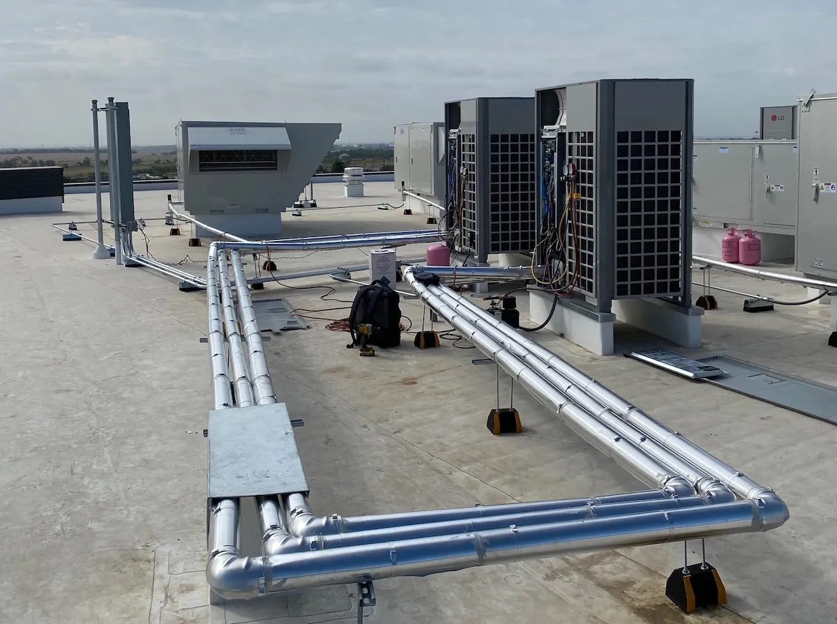Insulated refrigerant line sets running across a roof to LG VRF condensing units