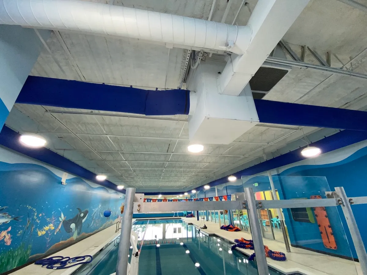 Ductwork and air handling equipment above an indoor swim school pool